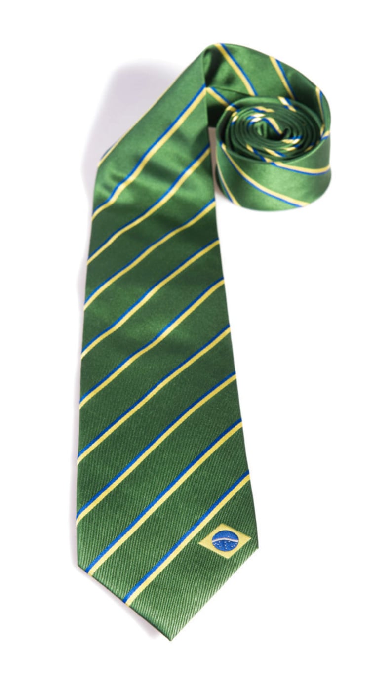 May include: A green and yellow striped tie with a small blue and yellow flag on the bottom right corner.