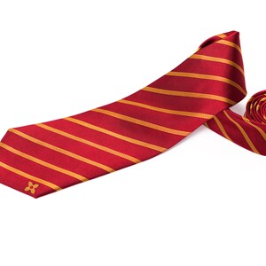 May include: A red and gold striped tie with a small gold flower design.