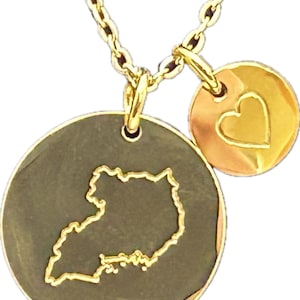 May include: Gold necklace with two pendants. The larger pendant is a round disc with an outline of the country of Uganda. The smaller pendant is a round disc with a heart shape inside.