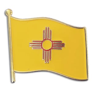 May include: A gold-colored pin with a yellow flag of New Mexico. The flag features a red symbol of the Zia sun symbol on a yellow background.