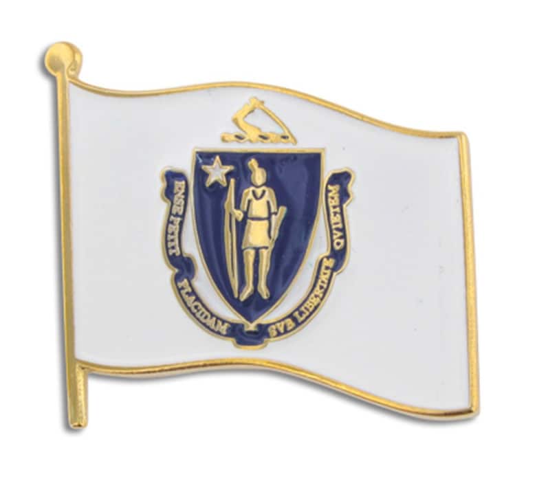 May include: A gold-colored metal pin with a white flag featuring the state seal of Massachusetts. The seal is blue with a gold outline and depicts a Native American man holding a bow and arrow. The text around the seal reads "Ense petit placidam sub libertate quietem".