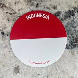 Może przedstawiać: Okrągła naklejka z flagą Indonezji. Górna połowa jest czerwona, a dolna biała. Naklejka ma napis "INDONESIA" nadrukowany na biało u góry i "STATEMANTIES.COM" nadrukowany na biało na dole.