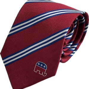 May include: A red striped tie with white and blue stripes and a small embroidered elephant with stars on it.