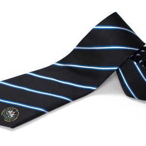 Op de afbeelding: Een zwart-blauwe gestreepte stropdas met een klein geborduurd embleem met een groene plant en de tekst "Seal of the United States Military Academy".