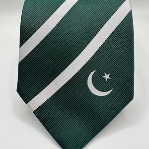 Op de afbeelding: Een groene en witte gestreepte stropdas met een wit halve maan en ster ontwerp.