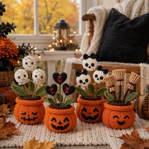 Może przedstawiać: Cztery szydełkowane pomarańczowe doniczki w kształcie dyni z twarzami jack-o'-lantern. Doniczki zawierają szydełkowane kompozycje trzech białych mumii, trzech czarnych serc z czerwonymi szwami, trzech białych czaszek z czarnymi kokardkami i trzech mioteł.