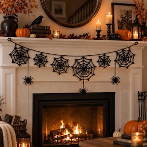 May include: A black crocheted garland featuring six intricate spider web motifs of varying sizes connected by a thin cord, with three small black spiders hanging from the webs at the left, center, and right ends of the decorative piece.