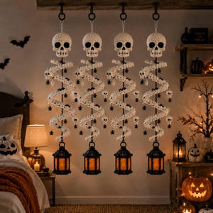 Puede incluir: Cuatro decoraciones colgantes con una calavera blanca de ganchillo en la parte superior, un cuerpo largo en espiral de ganchillo blanco adornado con pequeñas arañas negras y calaveras diminutas, y un farol negro con luz naranja cálida.