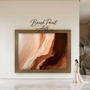 May include: A large rectangular wall art piece in a bronze frame featuring abstract fluid paint strokes in shades of cream, beige, tan, and deep chocolate brown. The text Brush Paint Arts is printed in black script above the framed artwork.