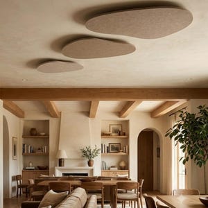Könnte beinhalten: Drei beige, organisch geformte akustische Deckenpaneele sind versetzt an einer glatten, hellen Decke über einem Wohn- und Essbereich mit Holzbalken, eingebauten Regalen und Möbeln in neutralen Farbtönen angebracht.