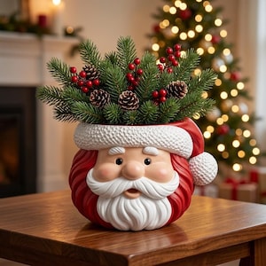 May include: A ceramic Santa Claus planter featuring a red hat with a white textured brim and pom-pom, a white moustache, and a beard. The planter is filled with green pine branches, small brown pinecones, and clusters of bright red berries.