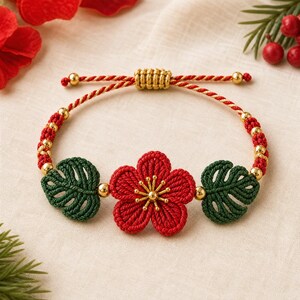 May include: A bracelet featuring a central red cord-woven flower with a gold-tone center, flanked by two dark green cord-woven monstera-style leaves. The band consists of red and gold twisted cord with small gold beads and an adjustable sliding knot.