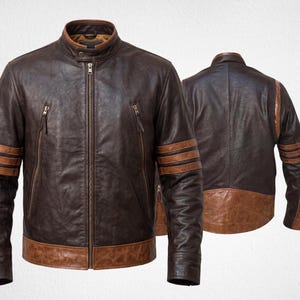 Può includere: Una giacca in pelle marrone scuro con colletto alla coreana, cerniera centrale e due tasche verticali con cerniera sul petto. Le maniche sono caratterizzate da tre strisce orizzontali in pelle color cuoio e l'orlo è rifinito con una fascia in pelle.