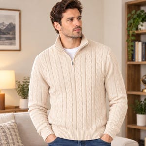May include: A cream-coloured cable knit jumper featuring a quarter-zip neckline with a silver-toned metal zip pull. The long-sleeved pullover is constructed with a textured vertical cable pattern and ribbed cuffs and hemline.