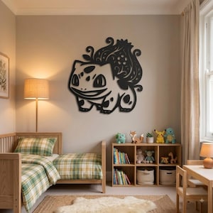 May include: A black metal wall art piece featuring a stylized, intricate silhouette of the creature Bulbasaur, characterized by its large bulbous plant on its back, pointed ears, and distinct facial markings, mounted on a plain light-colored wall.