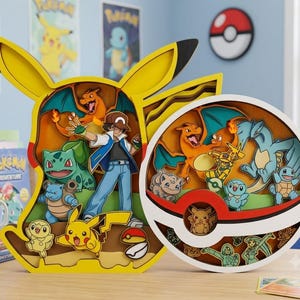Puede incluir: Una pieza de arte mural de madera en capas con forma de Pikachu, que presenta a Ash Ketchum y varios personajes Pokémon, junto a una pieza de arte circular de madera con temática de Poké Ball que contiene múltiples figuras Pokémon.