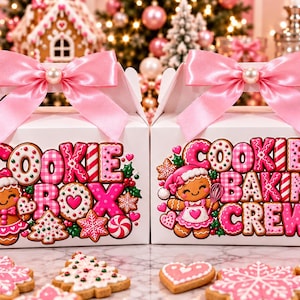 May include: Two white gable boxes with pink satin bows and pearl accents. The left box features the text COOKIE BOX and a gingerbread character. The right box features the text COOKIE BAKING CREW and a gingerbread character with a whisk.