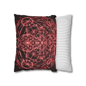 May include: A rectangular throw cushion featuring a dark black background with a vibrant red, intricate, symmetrical geometric pattern of intersecting circles and lines. The side of the cushion displays a contrasting white and grey horizontal stripe.