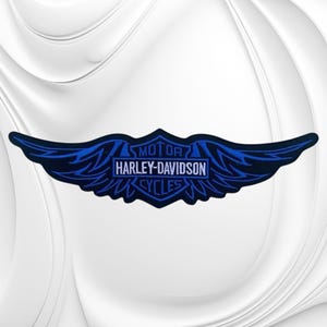 May include: A black and blue embroidered patch featuring the Harley-Davidson Motor Cycles logo with stylized wings extending from the sides. The text Harley-Davidson is centered in white within a rectangular frame, surrounded by blue wing details.
