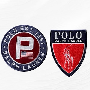 May include: Two embroidered fabric patches. The circular patch is navy blue with white text reading POLO RALPH LAUREN EST. 1967 and a large white letter P with a small American flag. The shield-shaped patch is navy blue and red with a white polo player.