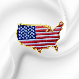 May include: An embroidered patch in the shape of the contiguous United States map. The design features the American flag pattern with a blue field of white stars on the left and horizontal red and white stripes across the rest of the map.