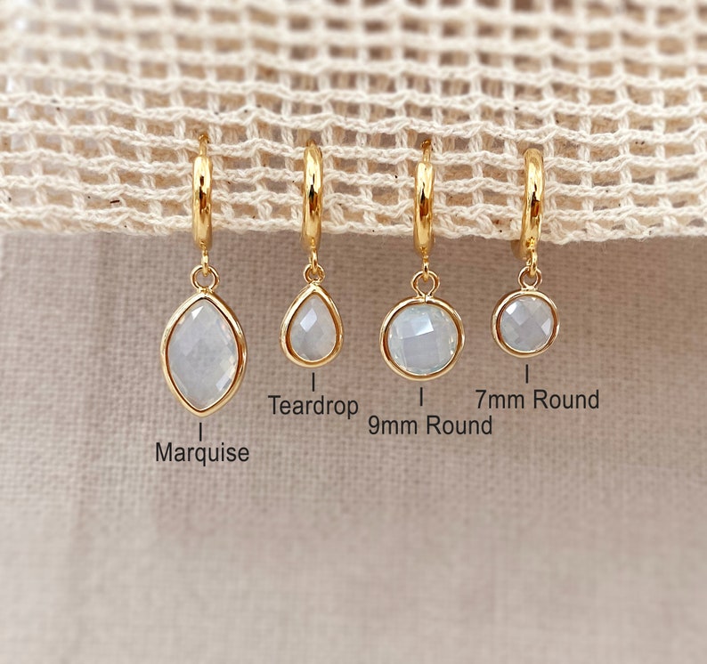 Pode incluir: Quatro brincos de argola de ouro com diferentes formas de pedras preciosas: marquise, gota, redonda de 9 mm e redonda de 7 mm.