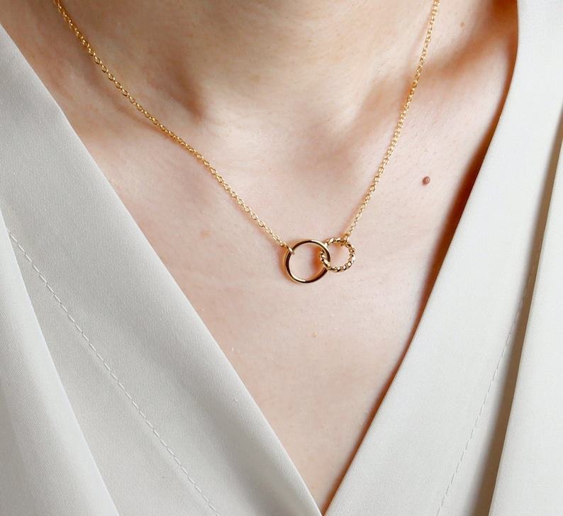 Puede incluir: Un collar de oro con dos c&iacute;rculos entrelazados. El c&iacute;rculo m&aacute;s peque&ntilde;o est&aacute; retorcido.
