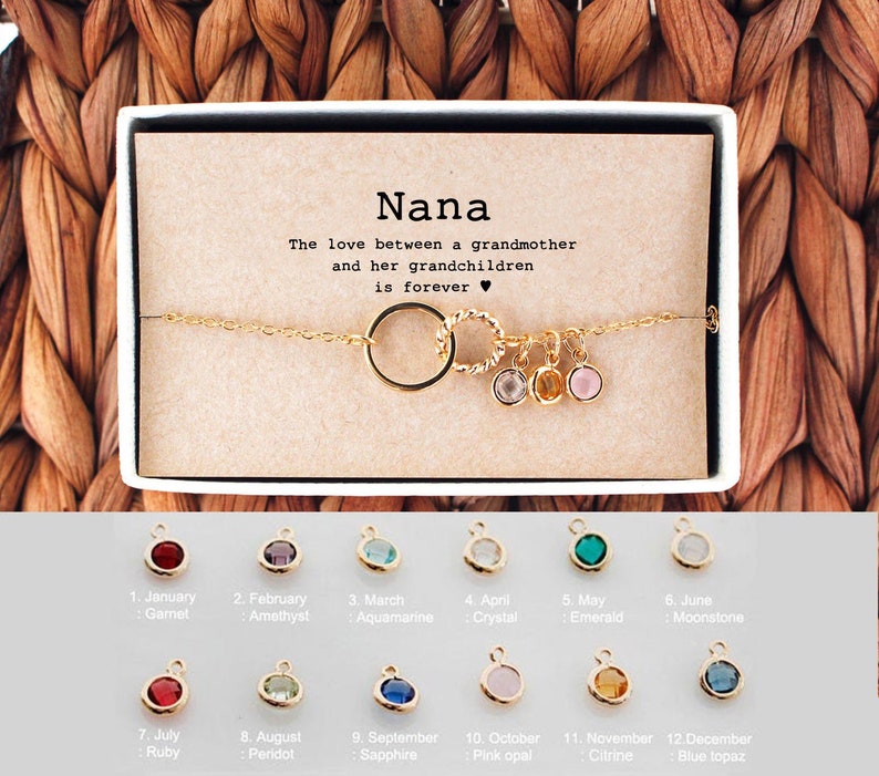 Gold chain bracelet with interlocking circle pendant, wrapped in a gift box with message card for nana. Customers can personalize it by adding birthstones for their nana. The most common comments about this bracelet are dainty and cute!