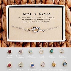 May include: A silver bracelet with a knot charm and a card that reads "Aunt & Niece The love between an aunt & niece knows no distance. No matter how far apart, always close at heart."