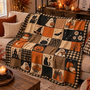 May include: A rectangular throw blanket featuring a patchwork design with alternating squares of black, orange, and cream. The pattern includes illustrations of black cats, ghosts, pumpkins, witch hats, bats, autumn leaves, and a haunted house.