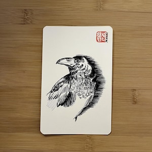 Könnte beinhalten: Eine rechteckige weiße Karte mit einer detaillierten schwarzen Tuschezeichnung eines Raben im Profil. Der Vogel ist mit feinen Schraffuren dargestellt. Ein kleiner roter quadratischer Stempel mit asiatischen Schriftzeichen befindet sich oben rechts.