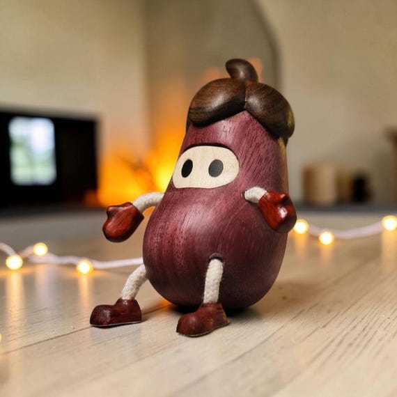 A tiny hand-carved beech wood acorn doll with kawaii charm — the kind of whimsical shelf creature that feels like it wandered out of a forest fairy tale.