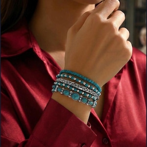 May include: A multi-strand bracelet set featuring turquoise-colored beads and silver-toned metal accents. The design includes smooth round beads, textured silver spacers, an intricate filigree metal band, and oval turquoise-colored stones.