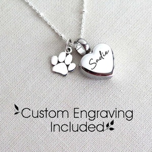 Könnte beinhalten: Silberkette mit einem herzförmigen Anhänger, der mit dem Namen "Sadie" graviert ist, und einem kleinen Pfotenanhänger. Individuelle Gravur ist im Lieferumfang enthalten.