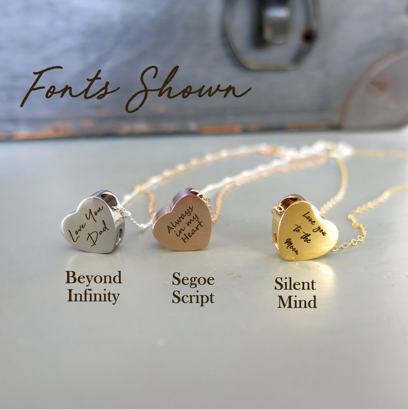 May include: Three silver, rose gold, and gold heart necklaces with different fonts and engravings. The silver necklace says "Love You Dad", the rose gold necklace says "Always in my Heart", and the gold necklace says "Love you to the Moon".