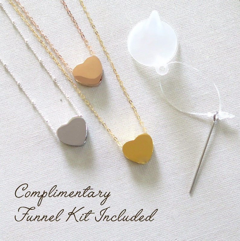 May include: Three silver, gold, and rose gold heart necklaces with a complimentary funnel kit for filling the heart pendants. The kit includes a clear plastic funnel and a needle.