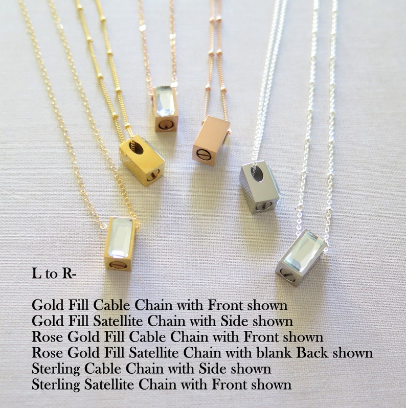 Six assorted rectangular urn pendants displayed on linen background. The cube shaped pendants have a screw in the bottom to add ash. Shown in gold, silver and rose gold. The front of the urn pendant has a clear beveled crystal piece glued on front.