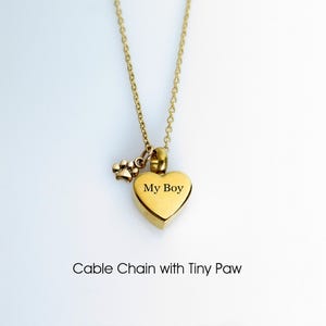 May include: Gold heart-shaped cremation necklace with a small paw charm. The heart has the inscription "My Boy" on it. Cable chain with tiny paw.