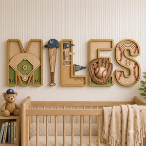 Op de afbeelding: Een set houten muurletters die MILES spellen met een honkbalthema. De M toont een honkbalveld, de I een honkbalknuppel met pet, de L bevat wimpels en de tekst OUTFIELD, de E een handschoen met bal, en de S heeft honkbalstiksels.