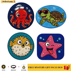 Puede incluir: Cuatro parches bordados con criaturas marinas: un pulpo rojo con gorro de marinero, una tortuga verde con gafas de sol, un pez globo amarillo y una estrella de mar rosa. El texto "Select any 2" aparece arriba y "FREE MYSTERY GIFT INCLUDED" abajo.