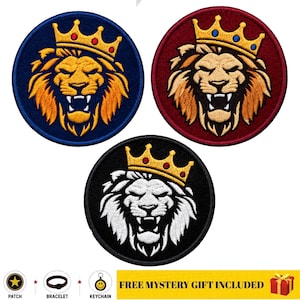 Puede incluir: Tres parches bordados circulares con una cabeza de león rugiente que lleva una corona dorada. Un parche tiene fondo azul, otro fondo rojo y el tercero fondo negro con un león blanco. El texto en la parte inferior dice FREE MYSTERY GIFT INCLUDED.