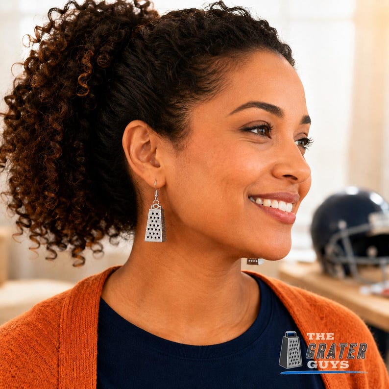 May include: A pair of silver-toned dangle earrings shaped like miniature kitchen cheese graters. Each earring features a rectangular body with a perforated surface pattern and a small metal loop at the top for attachment to the ear wire hook.