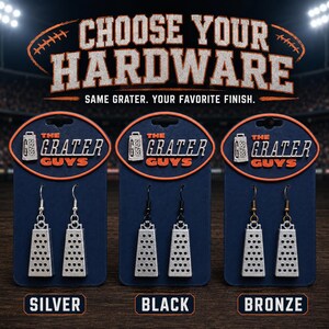 May include: Three pairs of silver-toned cheese grater earrings displayed on dark blue cards labeled The Grater Guys. The earrings feature silver, black, and bronze-colored hooks respectively. The text reads Choose Your Hardware, Same Grater. Your Favorite Finish.