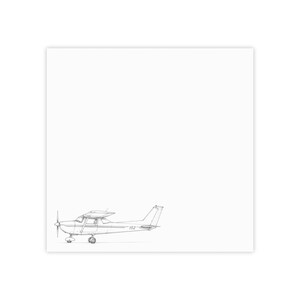 May include: A black and white line drawing of a small single-engine airplane positioned in the lower left corner of a square white background. The aircraft features a propeller, landing gear, and the number 152 clearly visible on the fuselage.