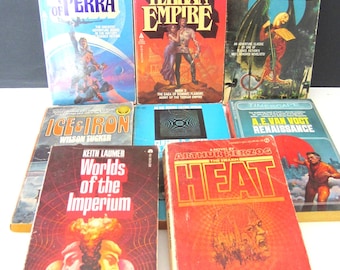 May include: A collection of vintage science fiction paperback books. Titles include "Flandry of Terra," "Agent of the Terran Empire," "War of the Wing-Men," "Ice & Iron," "Worlds of the Imperium," "Heat," and "Renaissance."