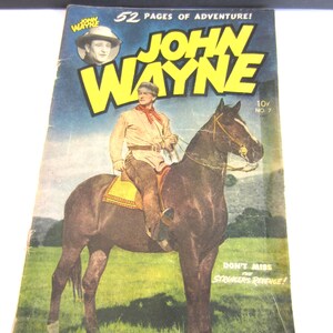 May include: A vintage John Wayne comic book, number 7, featuring a cover illustration of a person in western attire riding a dark horse in a field. The text reads 52 PAGES OF ADVENTURE, JOHN WAYNE, 10c, NO 7, and DON'T MISS THE STRANGER'S REVENGE.