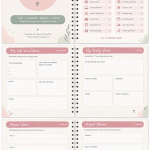May include: A spiral-bound planner titled Mum's Ultimate Life Planner with a soft pink and cream color scheme. The pages feature sections for daily planning, yearly vision, annual goals, and project tracking with organized lists and text fields.