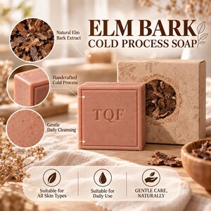 May include: A square bar of pinkish-brown soap embossed with the letters TQF, presented next to a matching cardboard box with a circular cutout showing elm bark. The packaging features the text ELM BARK COLD PROCESS SOAP and icons.