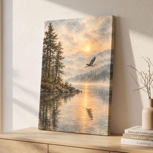 May include: A rectangular canvas print featuring a landscape painting of a lake at sunrise. Tall pine trees stand on a rocky shore, while a bird flies over the water. The scene is rendered in soft golden, orange, and muted blue tones.