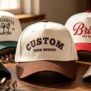 May include: Five baseball caps with off-white crowns and varied coloured brims. The caps feature embroidered text and graphics including 'MOJITO & Tipsy', 'MARGARITA EST 1986', 'CUSTOM YOUR DESIGN', 'Bride EST. 2025', and 'SUN SAL SAND' with a palm tree.